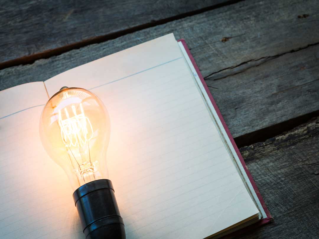 vintage book and light bulb on wood table